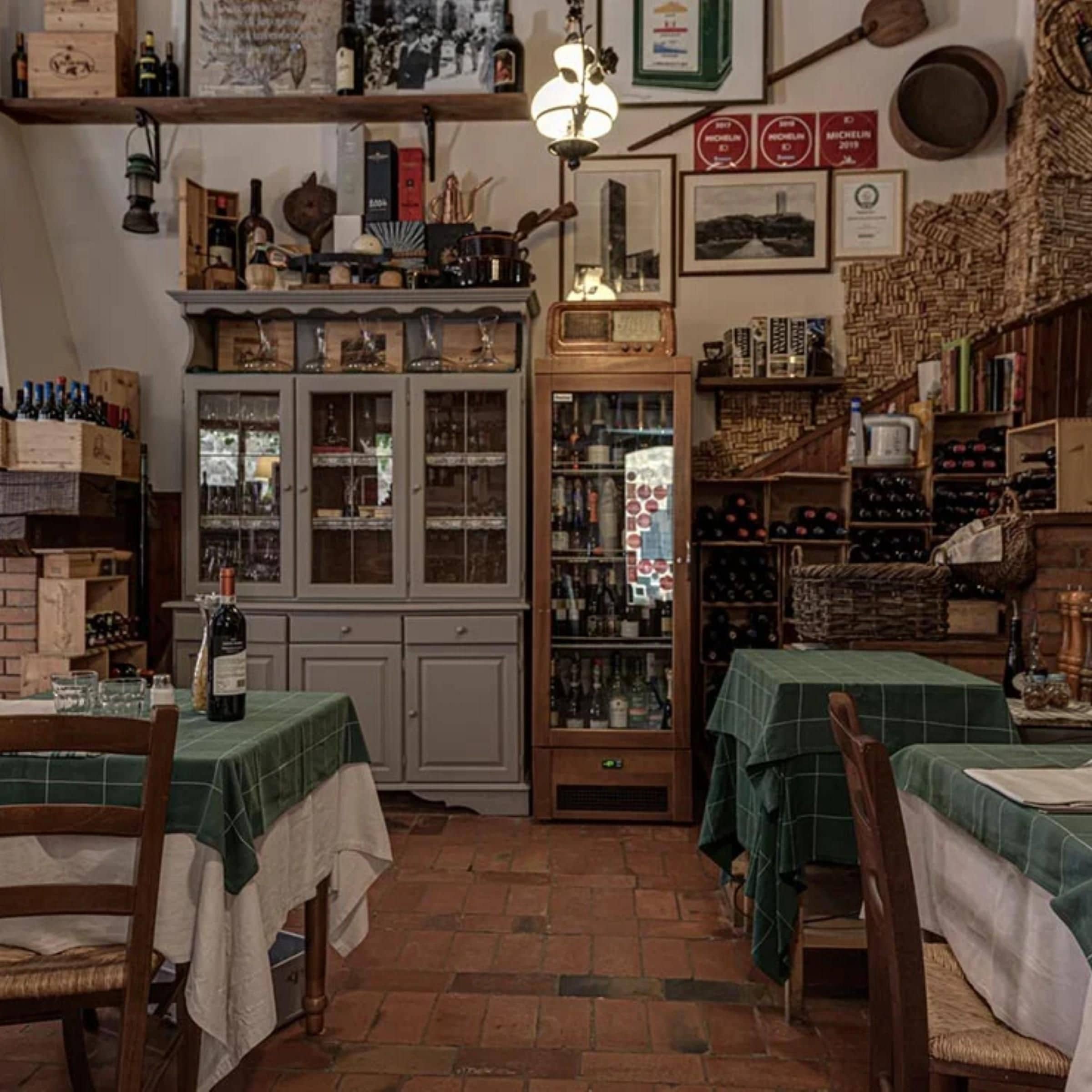 Ein gemütliches Restaurant-Interieur mit Holzkunst, einem alten Radio und verschiedenen Weinflaschen auf Regalen.
