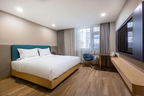 A hotel room with a bed, a desk, a chair, a television, and a window with curtains. - Cheermay Hotels (Beijing)