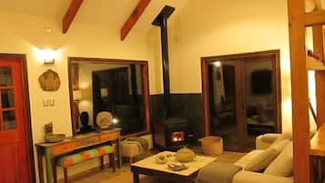 A cozy living room with a fireplace, a sofa, a coffee table, and a bench.