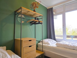 A room with a bed, a wooden dresser, a mirror, and a window with curtains. - We09 Holiday Home for 6 People (Westkapelle)