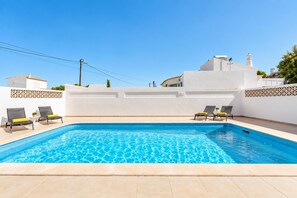 A swimming pool with two lounge chairs on each side, surrounded by white walls with decorative patterns. - Villa Lela - Two Bedroom Villa, Sleeps 4 (Vale Rebelho)