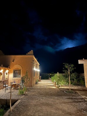 A building with a stone facade, a paved entrance, and outdoor seating. - Zaim Heritage Kasbah (Skoura)