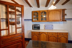 A kitchen with wooden cabinets, a microwave, and a tiled backsplash.