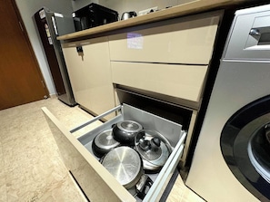 Een keuken met een inbouwoven, een magnetron en een roestvrijstalen afzuigkap.