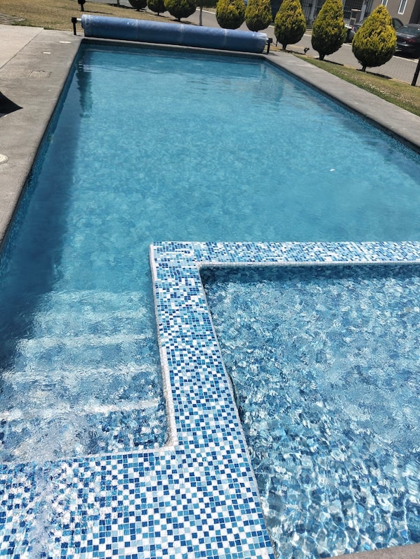 A swimming pool with a tiled edge and a clear blue water surface.