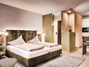 A modern bedroom with a large bed, a small seating area, and a kitchenette. - Holiday Apartment With 1 Bedroom (Willingen)