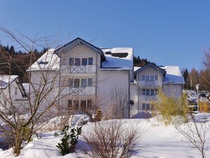 A multi-story residential building with a snow-covered roof and a balcony. - Holiday Apartment With 1 Bedroom (Willingen)