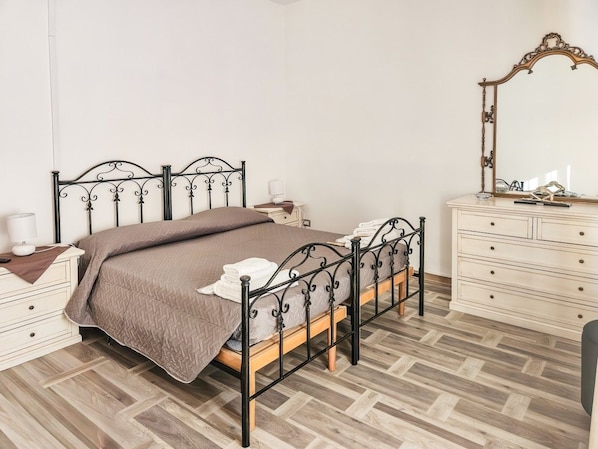 A bedroom with a bed, bedside tables, a dresser, and a mirror.