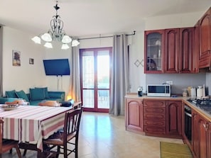 Un'area pranzo con tovaglia a righe, sedie di legno e un lampadario.