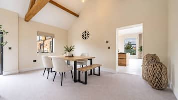 A spacious room with a dining area, a large window, and a view of the outdoors.