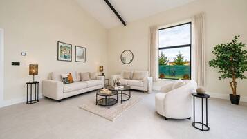 A modern living room with two sofas, a coffee table, and a potted plant.
