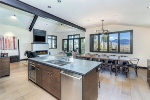 A modern kitchen with a large island, built-in appliances, and a dining area with a view of the mountains. - Canyon View Escape 6 bedrooms sleeps 16 (Telluride)