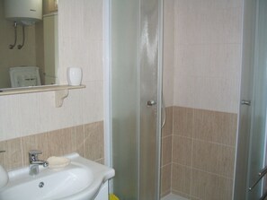 Ein Badezimmer mit Waschbecken, Spiegel und Dusche.