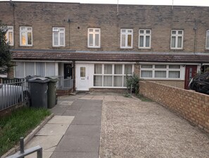 Ein Wohngebäude mit Vorgarten, Garage und Auffahrt.