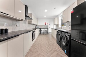 Cozinha moderna com micro-ondas, forno e máquina de lavar.