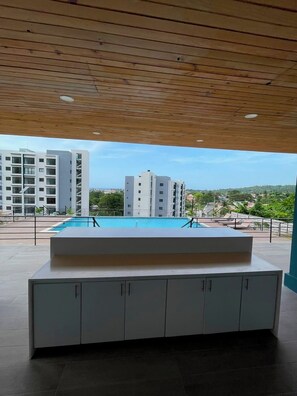 Ein modernes Hotelzimmer mit Holzboden, einem Pool und Blick auf die umliegenden Gebäude.