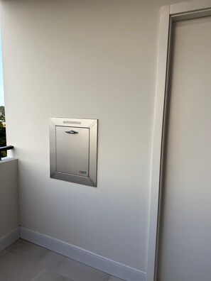 Una pared blanca con un timbre metálico montado.