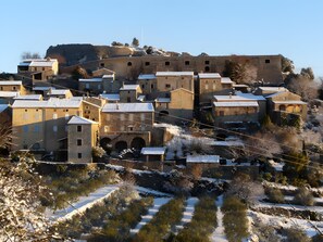 A historic town with stone buildings, a prominent hilltop structure, and a snow-covered landscape. - Holiday Home 'Cabane De La Grande Ourse -' with Mountain View, Private Garden and Wi-Fi (Banne)