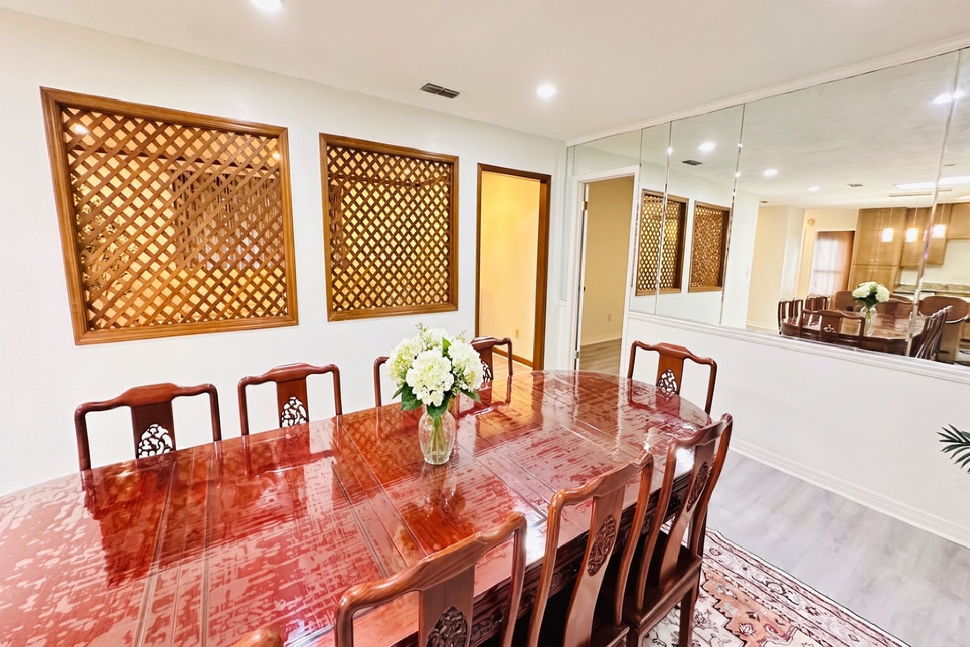 A conference room with a long table, six chairs, and decorative wooden panels.