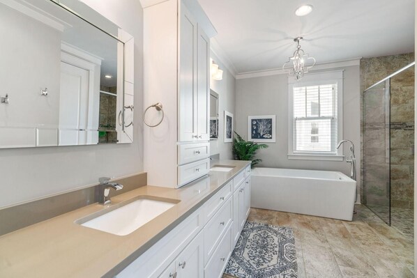 A modern bathroom with a large mirror, a bathtub, and a shower area. - Blue Grouper (Santa Rosa Beach)