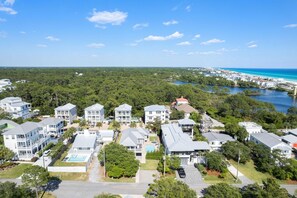 A coastal residential area with multiple two-story houses, a swimming pool, and a view of the ocean. - Blue Grouper (Santa Rosa Beach)