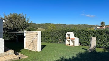 Un espacio al aire libre con césped, un muro de piedra y una valla de madera.