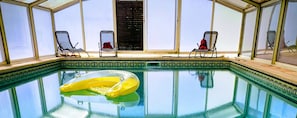 Piscina com espreguiçadeiras e um solário.
