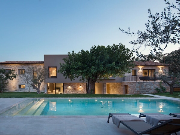 A modern two-story house with a swimming pool, stone walls, and a tree in the yard. - Villa in Porec With Swimming Pool (Porec)
