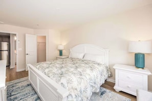 A bedroom with a bed, nightstands, a lamp, and a wardrobe. - Luxury Apartment/ Sleeps 4/ Marina/ Pool/ West OC (Ocean City)