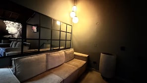 A room with a sofa, a large mirror, and a light fixture. - BEST Apartment in Manila with a Jacuzzi (Medellín)