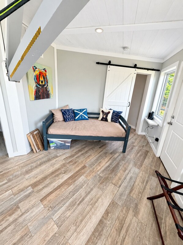 A bedroom with a bed, a painting, and a window. - Slopesider 11 Ski-In Ski-Out Home with view and deck (Sugar Mountain)