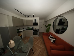 Eine moderne Küche mit Essbereich, einer Couch und einem großen Spiegel.