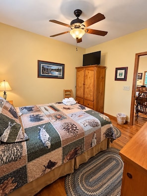 A bedroom with a bed, a ceiling fan, a wooden cabinet, a television, and a framed picture on the wall. - Eagle Rock - Hot Tub, Firepit, Gas Fireplace, Rec Room (Beech Mountain)