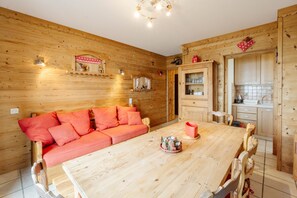 Ein gemütliches Holzinterieur mit einer Couch, einem Esstisch und einer Küchenzeile.