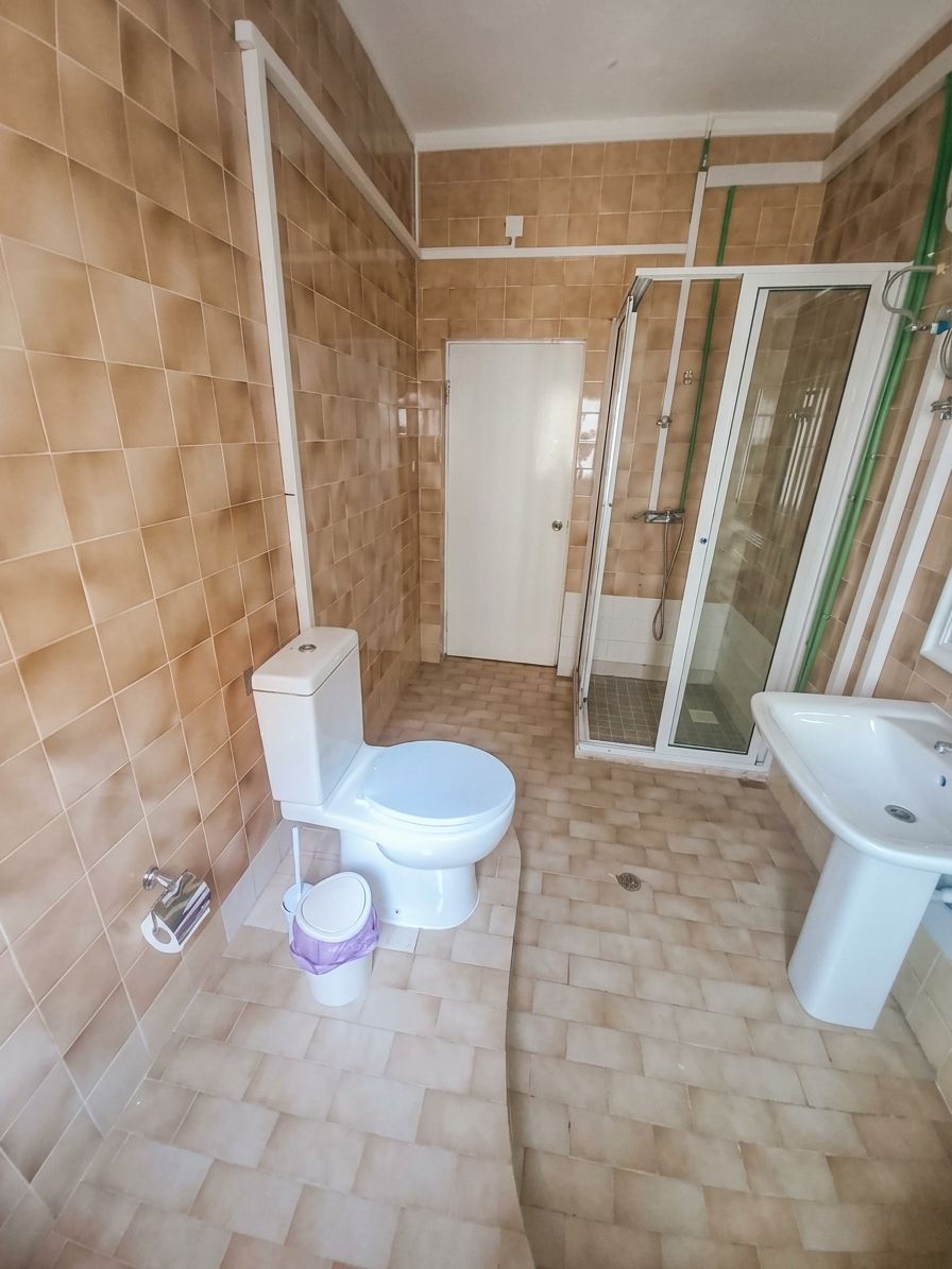 A bathroom with a toilet, bidet, and shower enclosure.