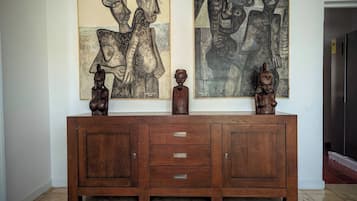 Un meuble en bois avec des tiroirs et deux sculptures posées sur le dessus.