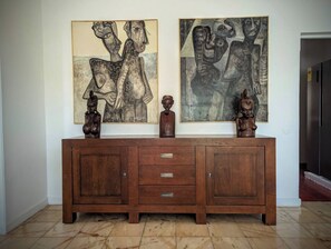 Un mueble de madera con cajones y dos esculturas encima.
