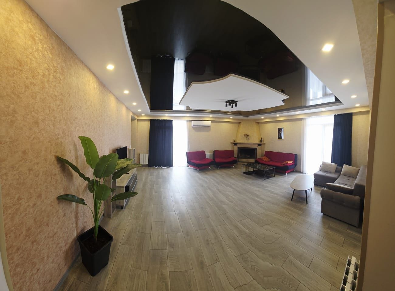 Un vaste espace de vie doté d’un haut plafond, d’une cheminée et de différents coins salon.