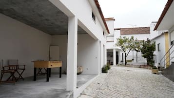 Un patio con una mesa de fútbol de mesa, una silla y una puerta.