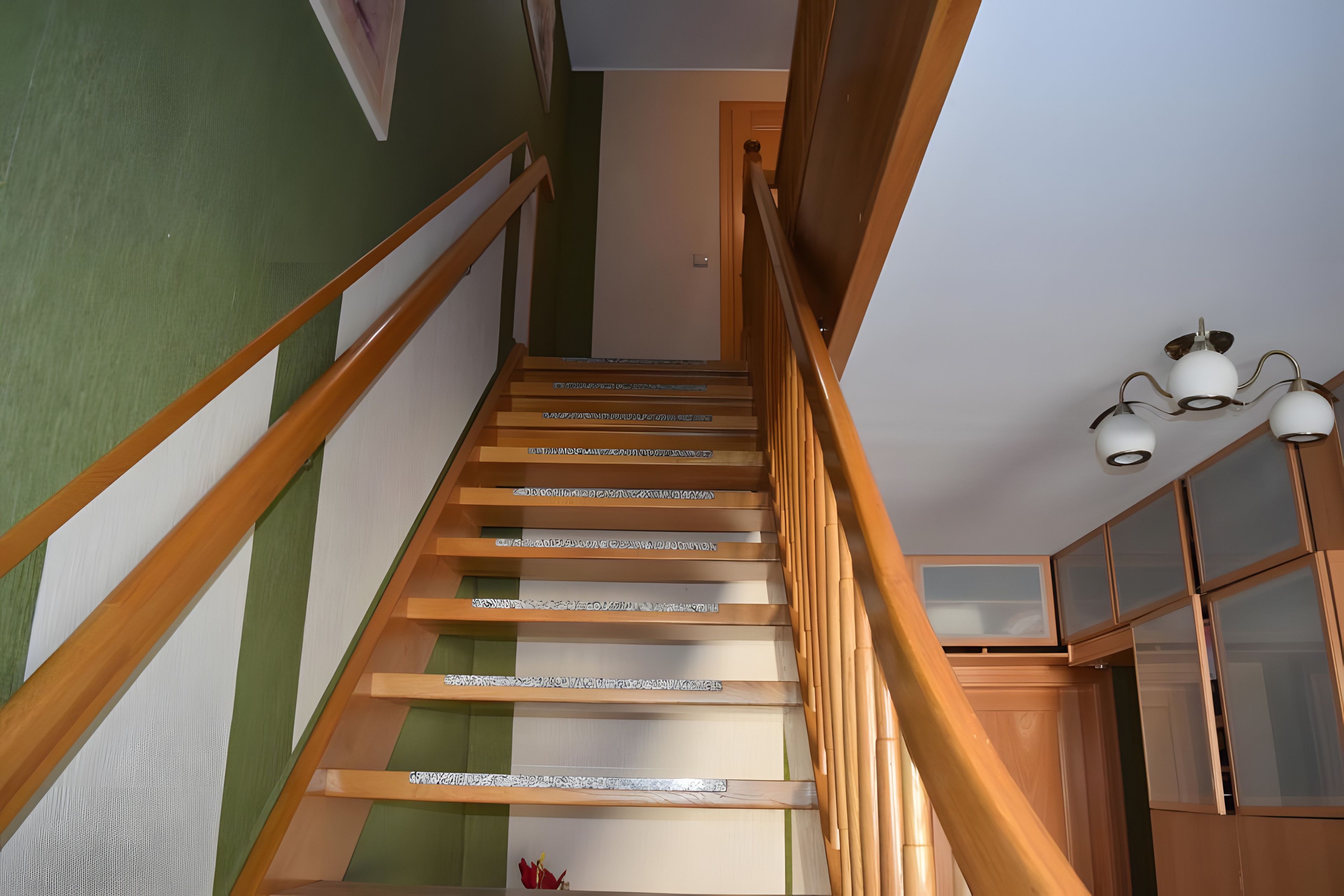 Un escalier en bois, doté d’une rampe, mène à un palier.