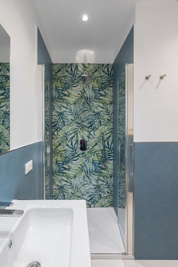 Ein Badezimmer mit Dusche, Waschbecken und Spiegel.