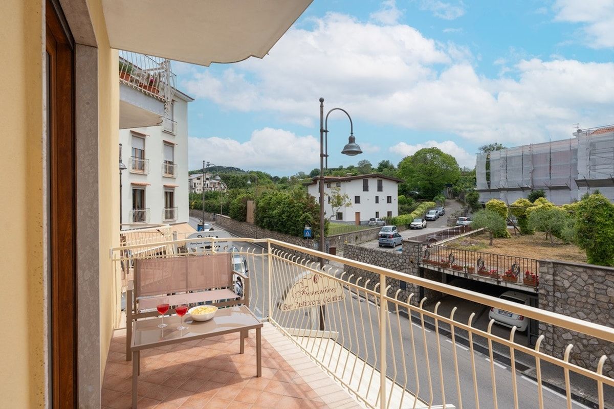 Ein Balkon mit Tisch, Stühlen und einer Weinflasche.