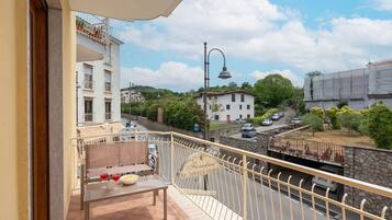 Ein Balkon mit Tisch, Stühlen und einer Weinflasche.