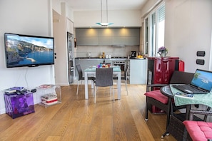 A compact living space with a dining area, kitchenette, and a television mounted on the wall. - Maya Penthouse - Sorrento Center (Sorrento)