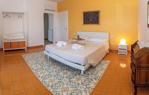 Ein Hotelzimmer mit Bett, Nachttisch, Schrank und einer Badezimmertür.