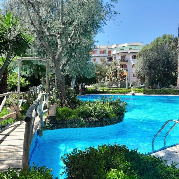 A swimming pool surrounded by greenery and a building in the background. - La Deliziosa - Sorrento (Sorrento)