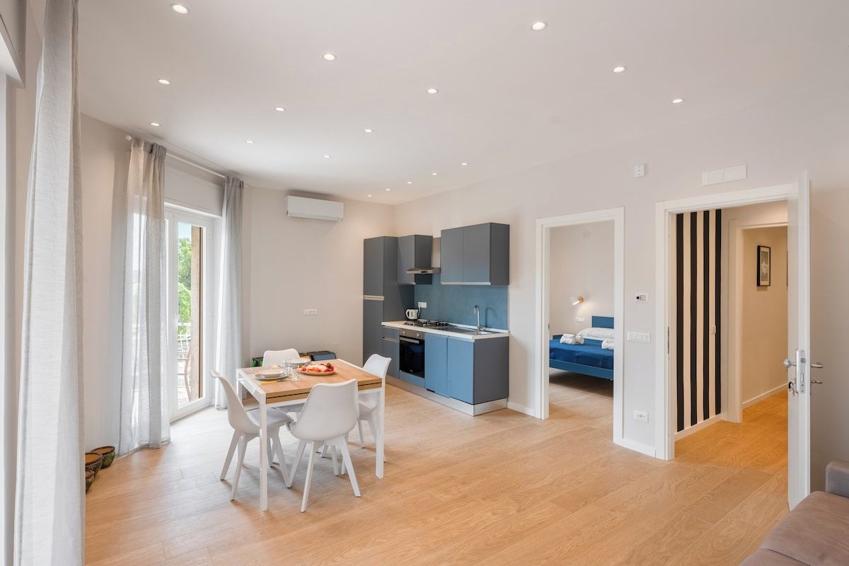 Eine moderne Wohnung mit Essbereich, Küchenzeile und Schlafzimmer.