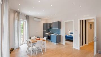 Eine moderne Wohnung mit Essbereich, Küchenzeile und Schlafzimmer.