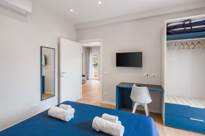 Une chambre à coucher avec un lit, un bureau, une chaise, une télévision et une armoire.