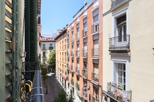 A narrow street with multi-story buildings, balconies with railings, and a clear sky. - M Cer822 Apartamento de 1 Dormitorio con Balc n (Madrid)